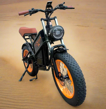 Load image into Gallery viewer, A black and orange Kugoo Kirin V5 electric bike with a prominent headlight and fat tires, displayed indoors.
